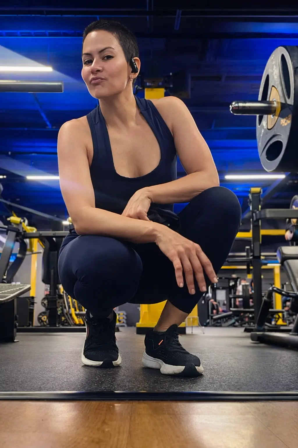 Mujer en gimnasio en pose con mueca