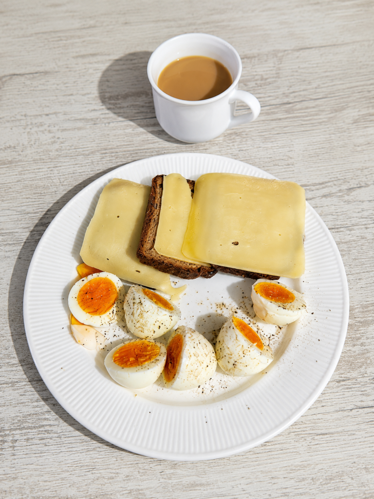 Desayuno, tres huevos, tostada de pan con proteina, queso y café